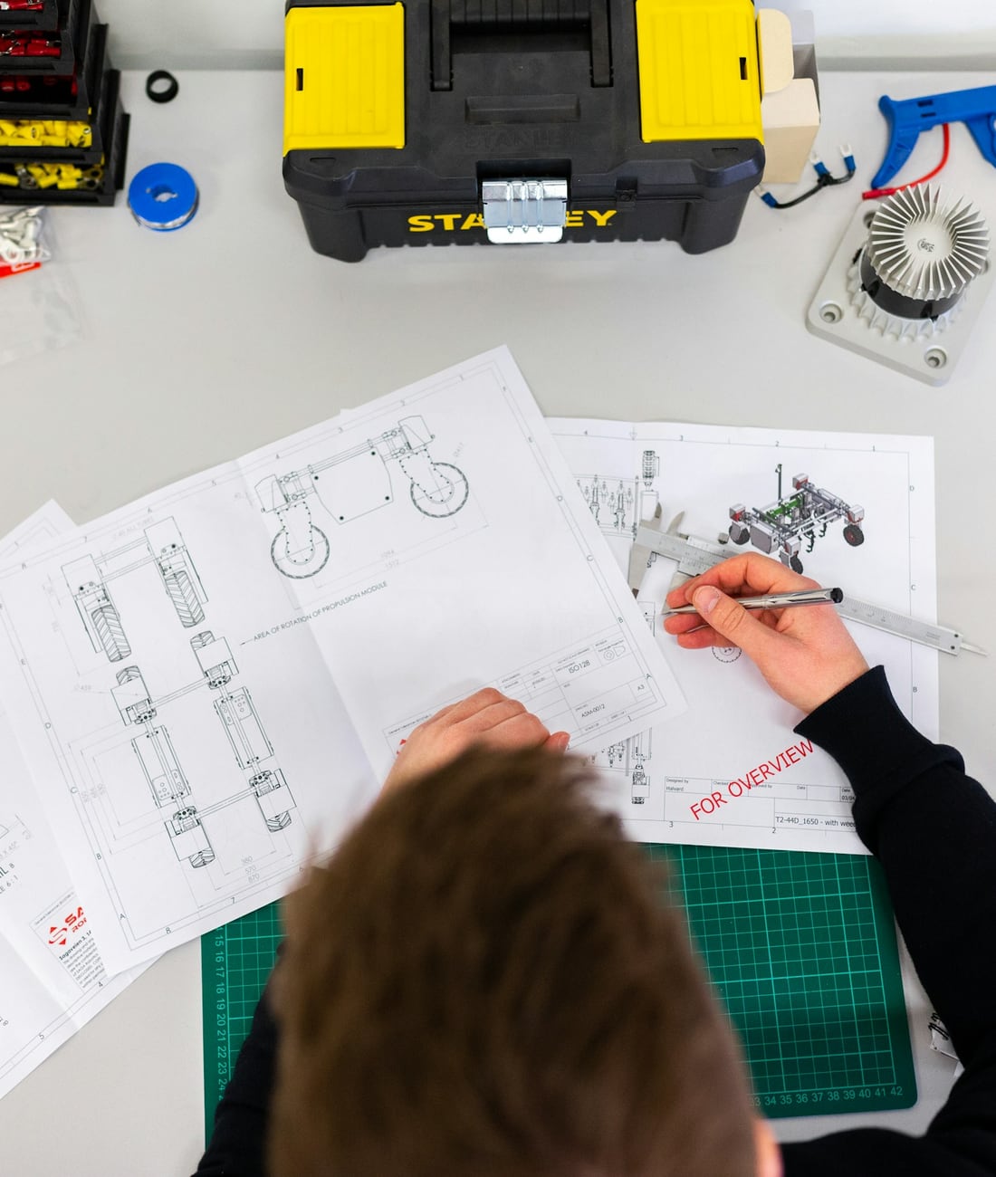 Planos técnicos y herramientas de medición sobre una mesa de taller